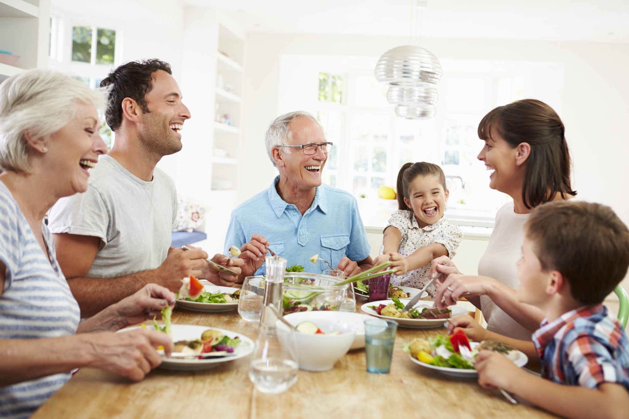 Family Laughing at Dinner Table