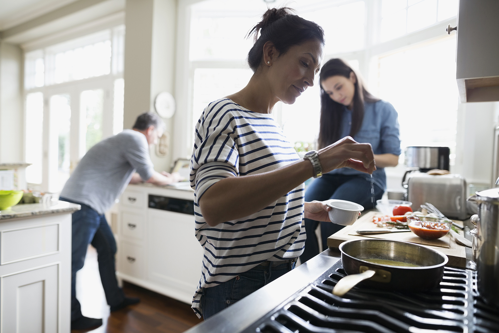 Woman cooking at stove in kitchen